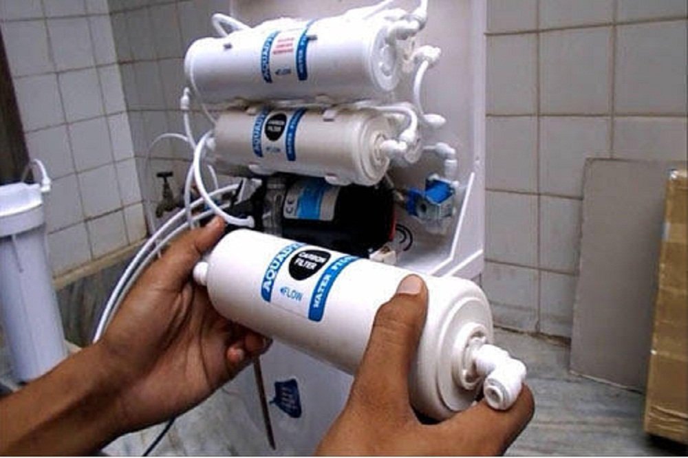Technician inspecting a leaking RO water purifier in Pune